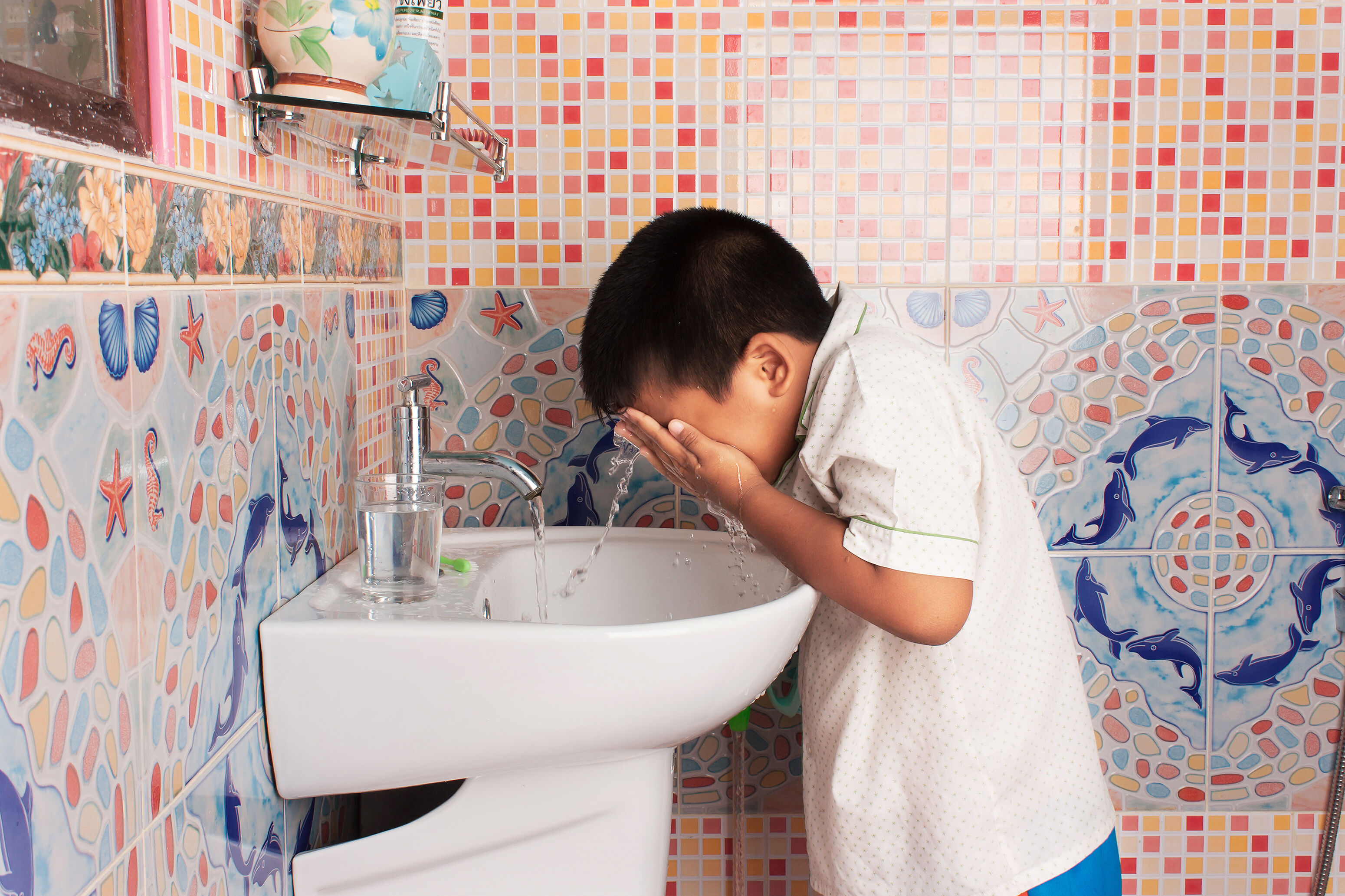 Boy washes his eyes