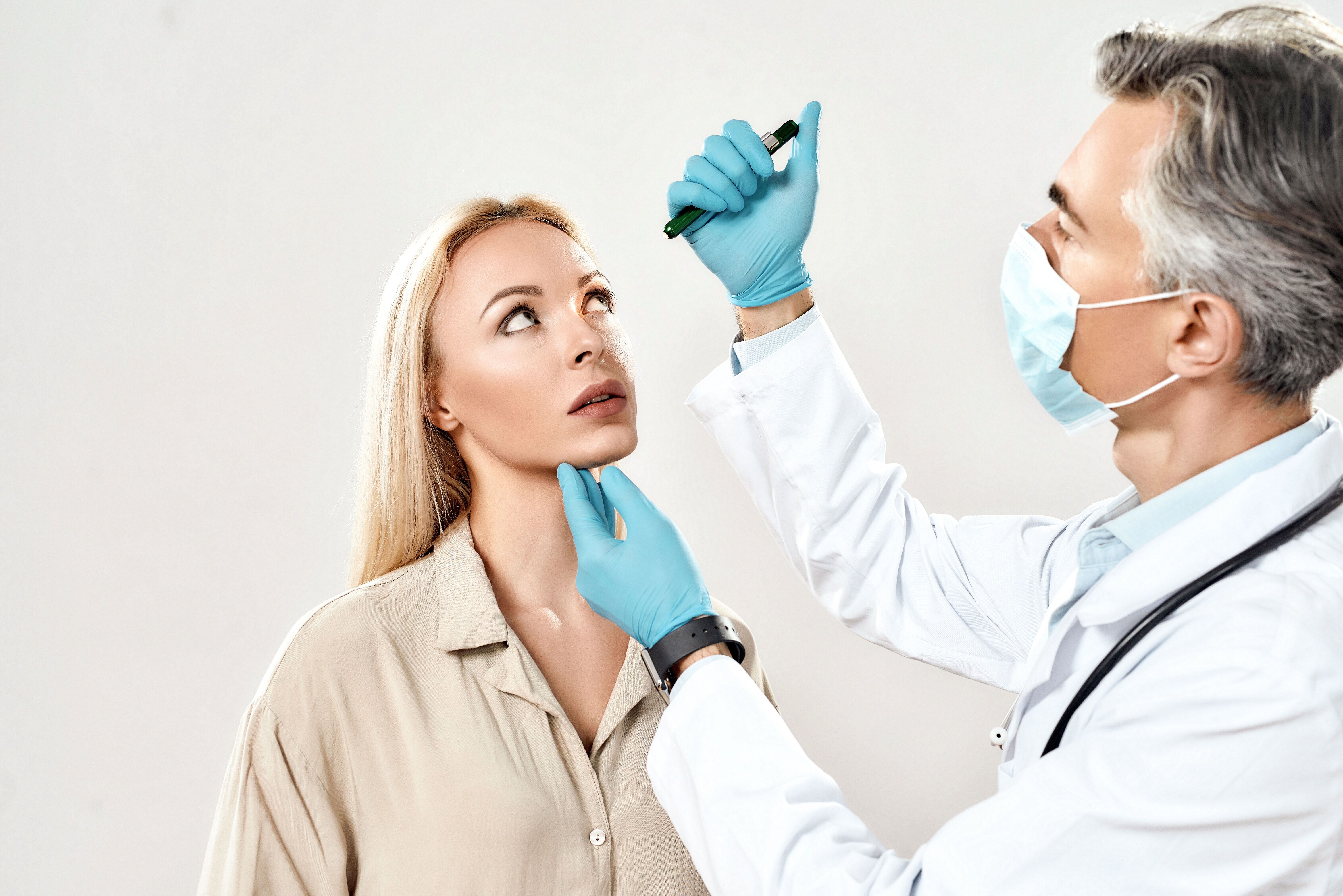 The doctor checks the patient's visual reflexes