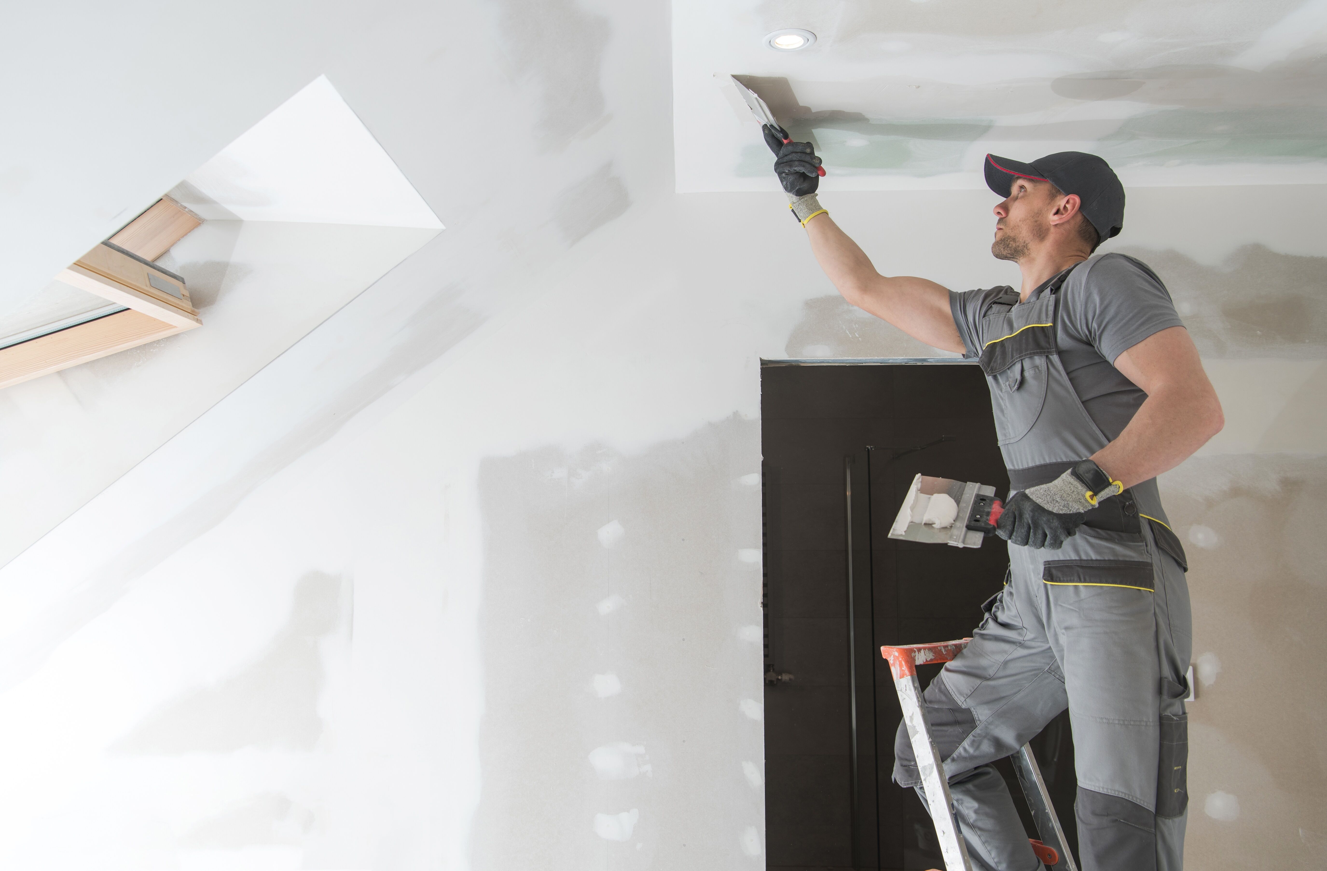 Worker putties the ceiling